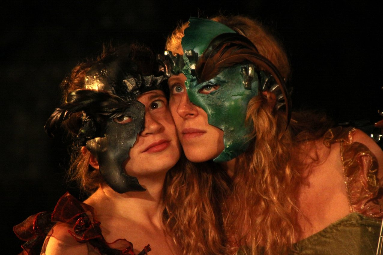 The Tempest, two performers in fantastical half-face masks