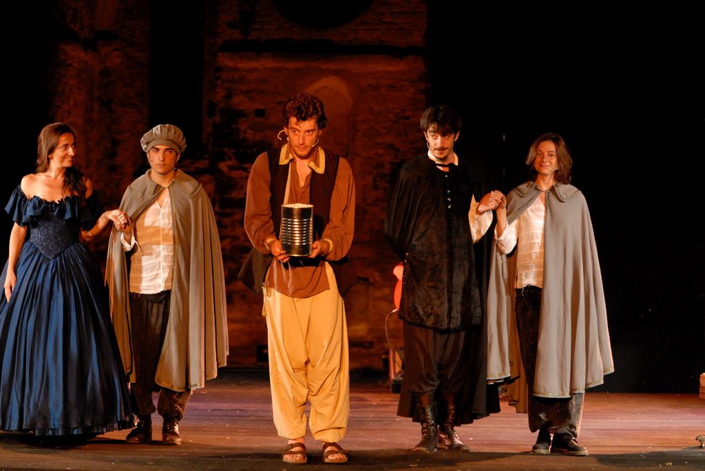 La XII Notte, five actors in period costume, one holding a tin can