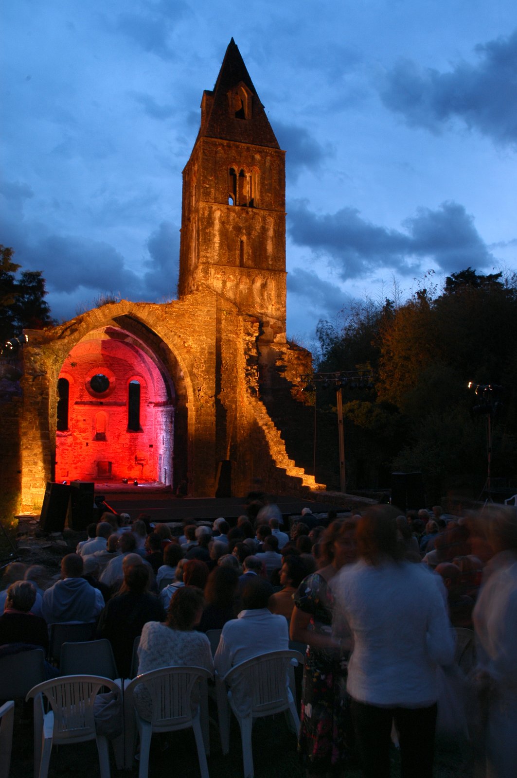 The archaeological remains of the Medieval monastery of Valle Christi, Rapallo, with the nave lit red and the audience seated